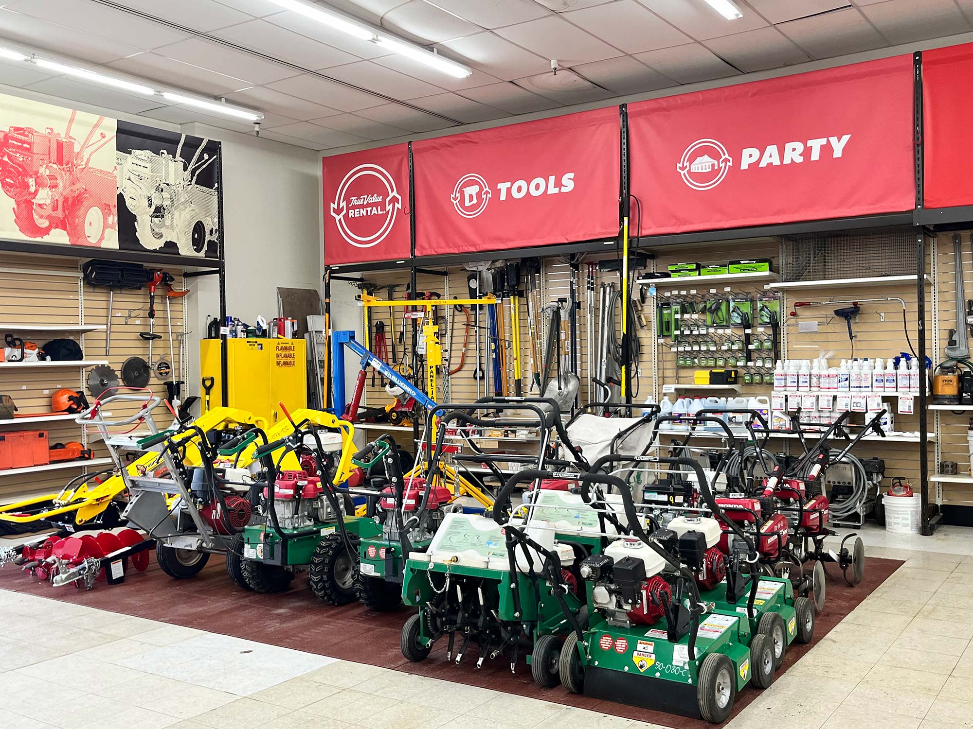 A store section showcasing a variety of gardening equipment and tools for rental. Shelves and displays are filled with different machines, tools, and products, with signage overhead indicating tool rentals.