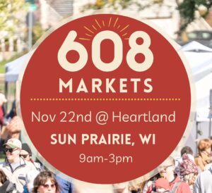 Large red circular sign with "608 Markets, Nov 22nd @ Heartland, Sun Prairie, WI, 9am-3pm" over a blurred outdoor market scene with people.